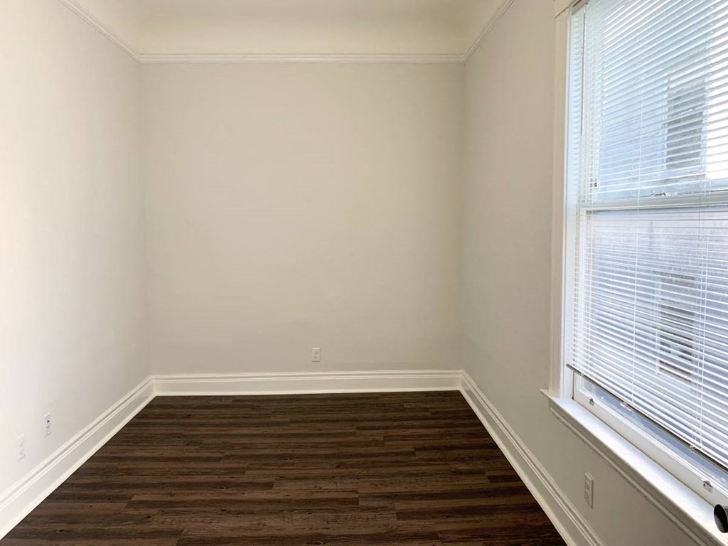 a room with a large window and wooden floors