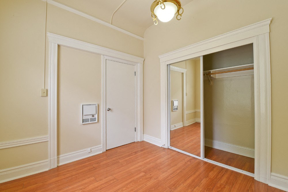 a living room with a mirror and a door to a closet