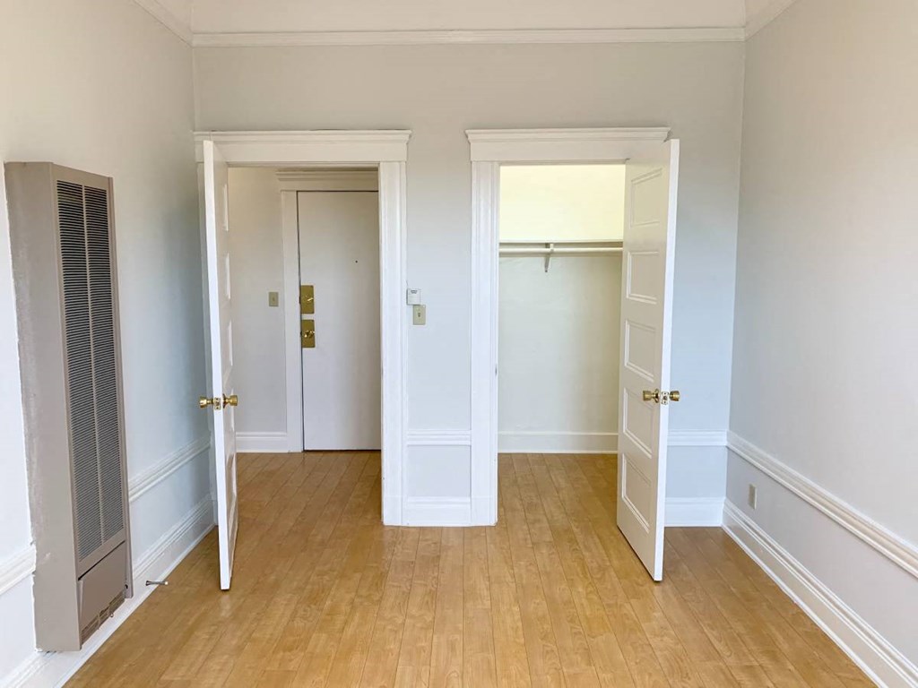 a bedroom with two closets and a hard wood floor