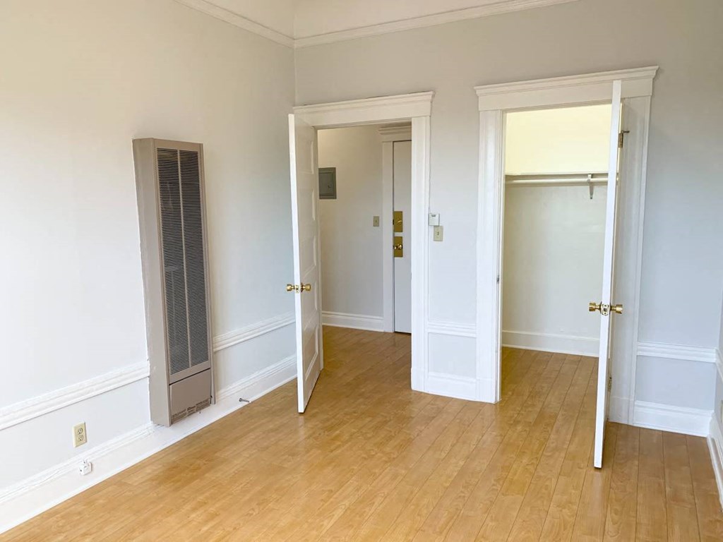 a room with a wood floor and white walls and doors