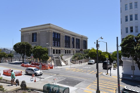 the city hall on the corner of a city street