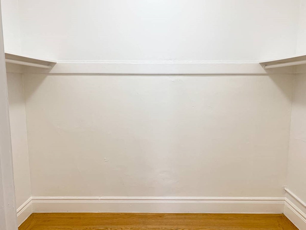 an empty room with white walls and a wooden floor