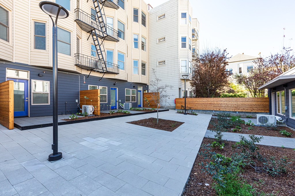 the back yard of an apartment building with a patio