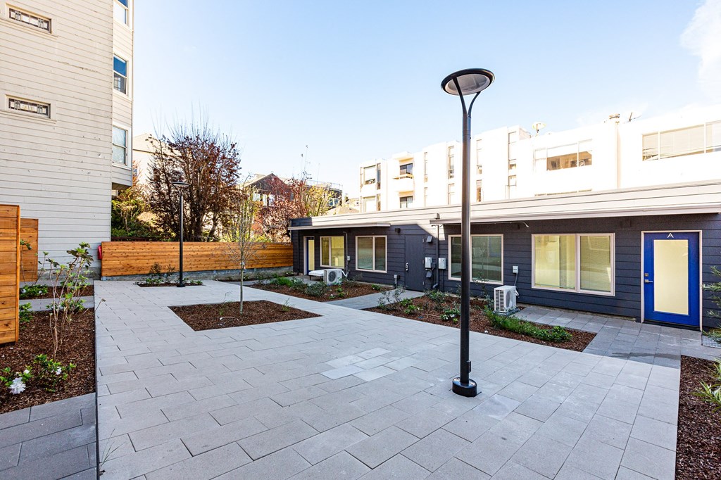 a courtyard with a light pole in front of a building