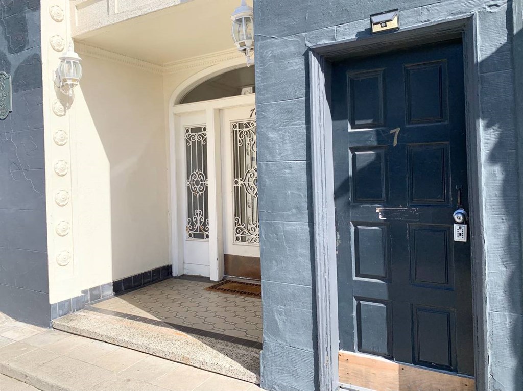 the front door of a building with a black door and a window