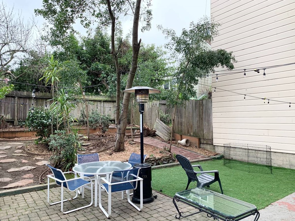 a backyard patio with a table and chairs and a bird feeder