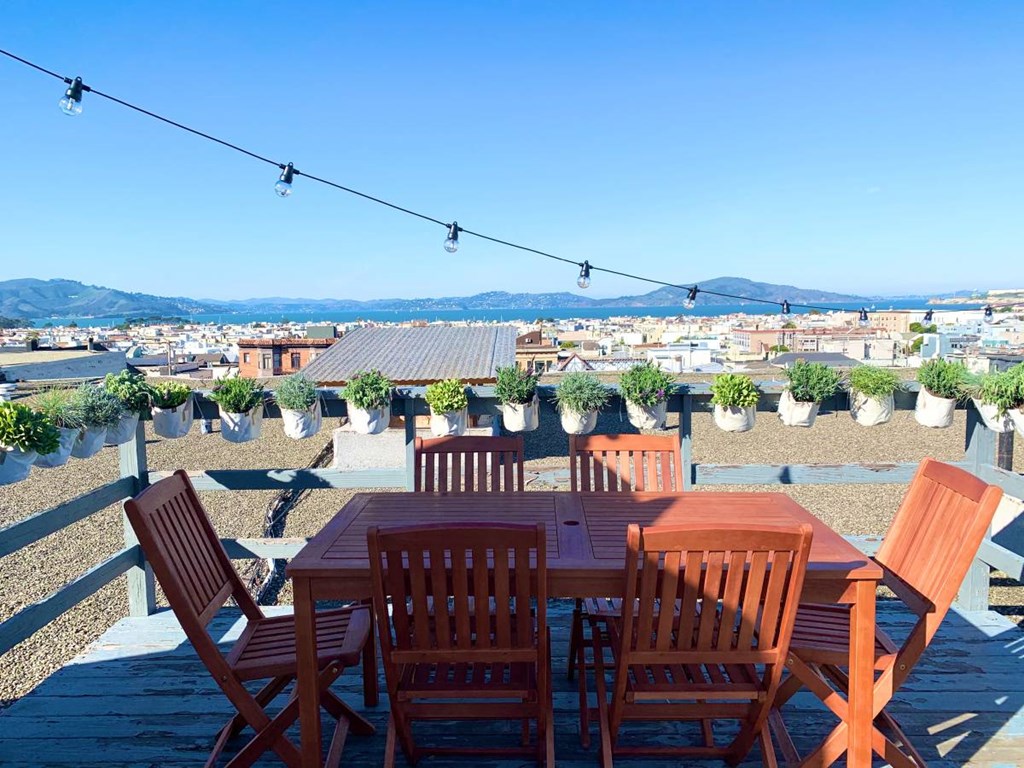 a table and chairs on a roof with a view of the city