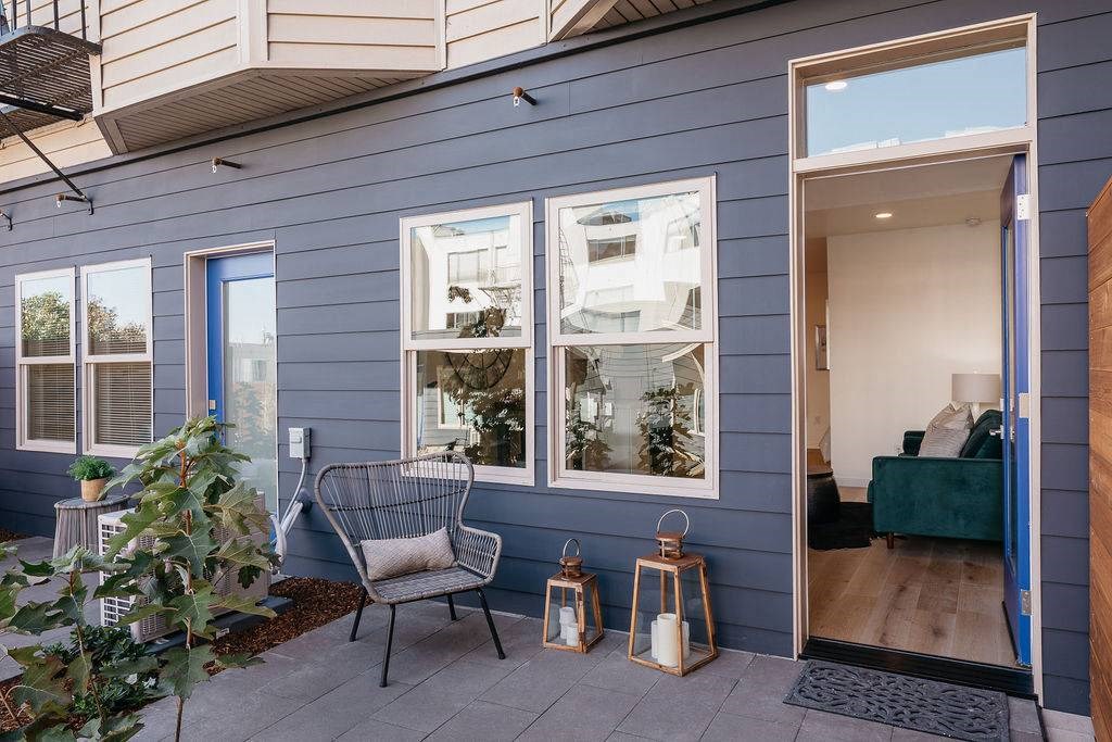 a patio with a chair and a blue house