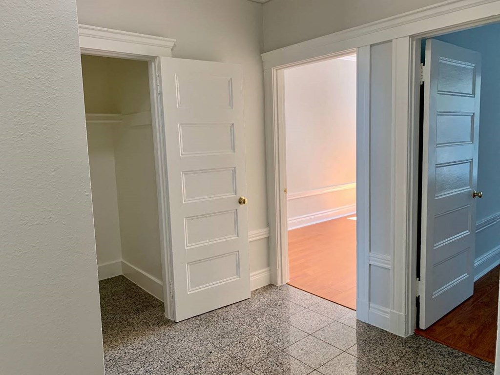 a room with two doors and a hallway with a door open