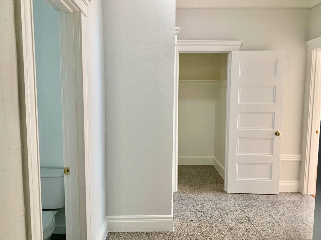 a room with a closet and a toilet and an open door