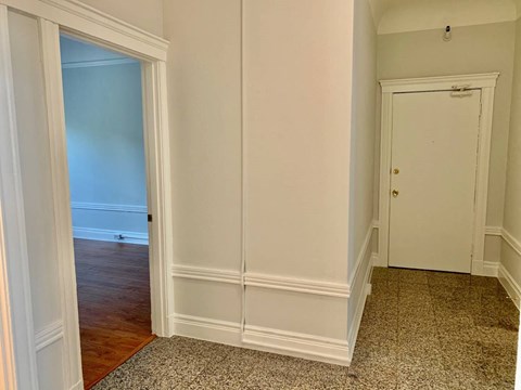 a hallway with a door to a bedroom and a closet