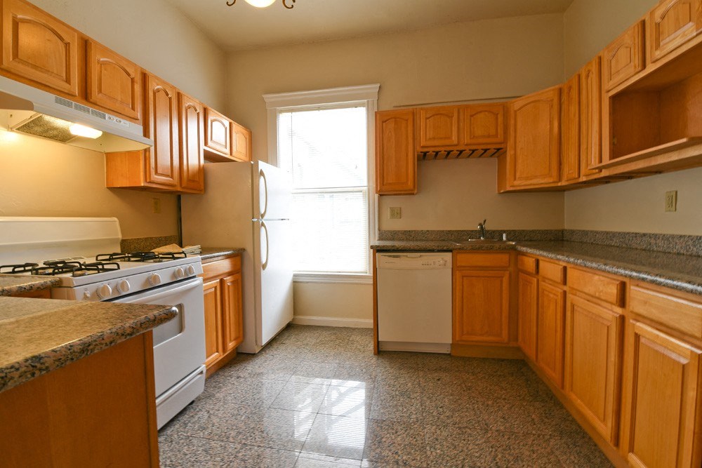 a kitchen with wooden cabinets and white appliances