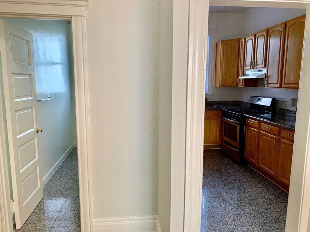 a kitchen with wooden cabinets and a door into it