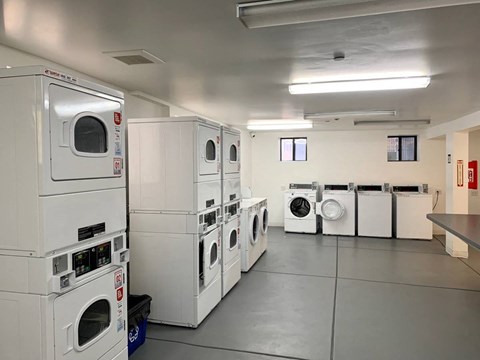 a laundry room filled with lots of white washing machines