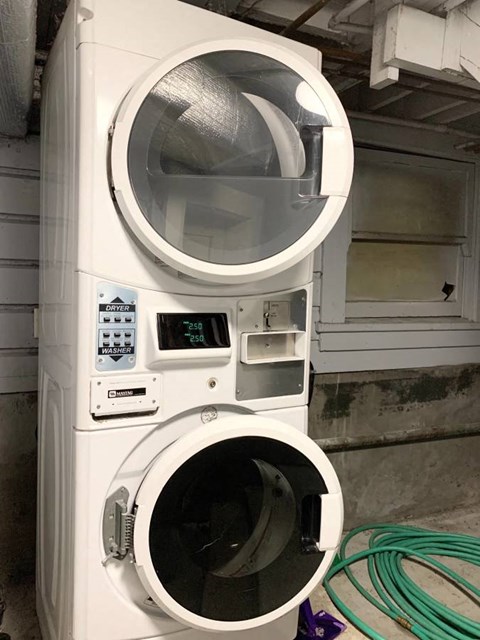 A large industrial washing machine with a digital display and control panel.