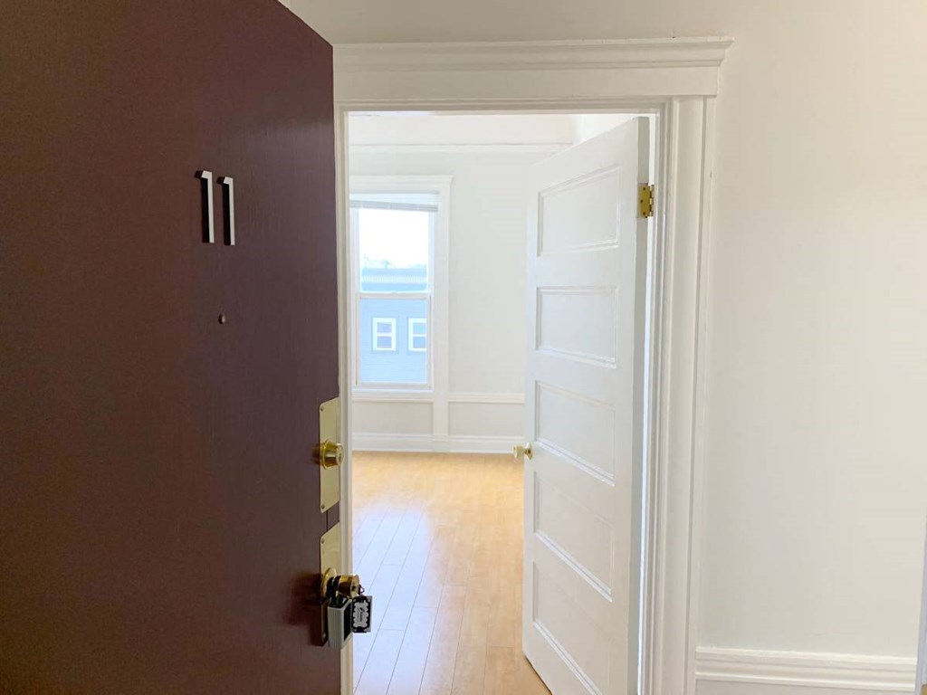 the door is open to a empty room with a window