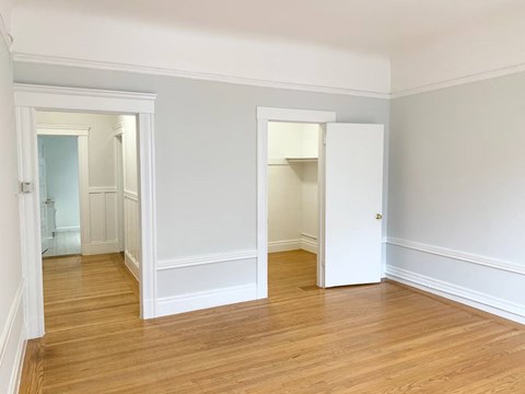 an empty room with white walls and a wood floor