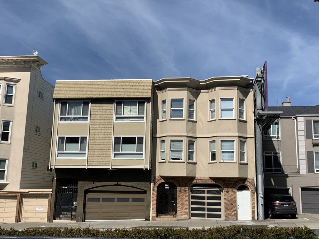 a three story apartment building with a car garage