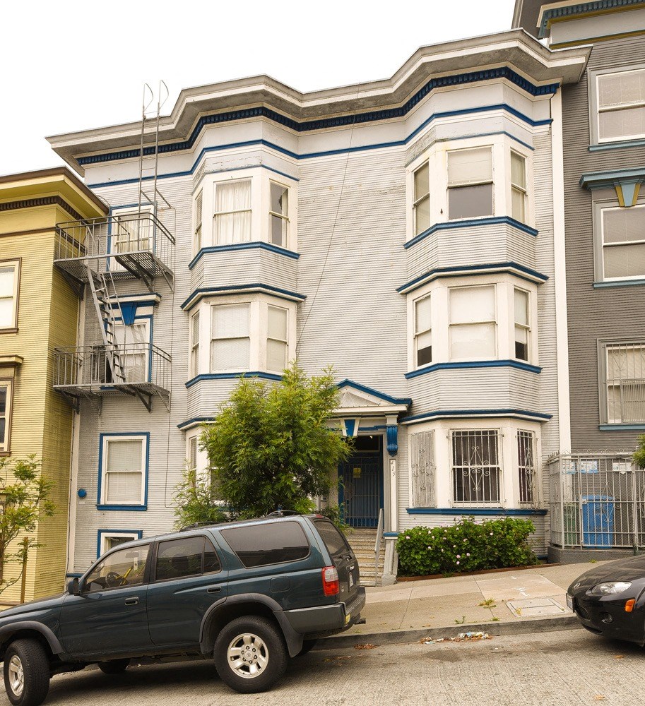 a blue truck parked in front of an apartment building