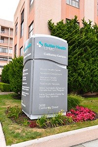 a sign in the grass in front of a building