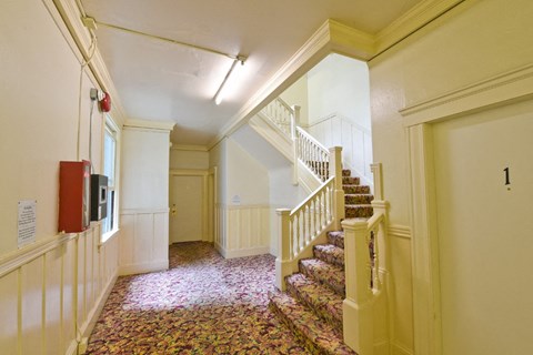 the entrance hall of a house with a staircase and a door