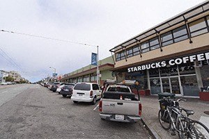 a row of cars parked in front of a starbucks coffee shop