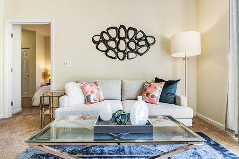 a bright, sunlit, living room with a couch and coffee table