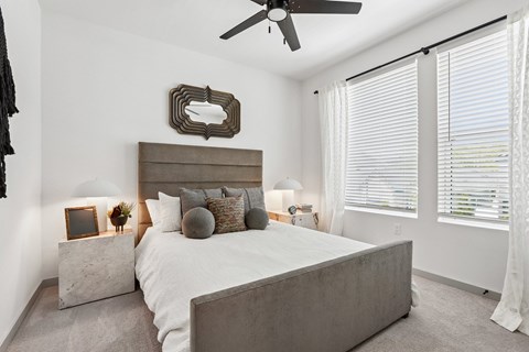 A bedroom with a large bed and a ceiling fan.