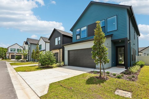 A blue house with a tree in front.