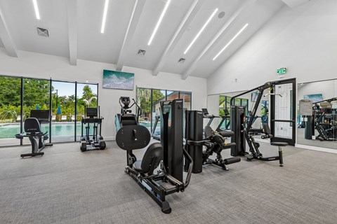 A gym with a variety of equipment including treadmills, weights, and exercise machines.