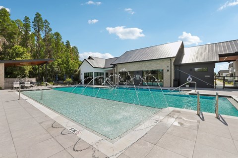 A large outdoor swimming pool with a building in the background.