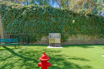 A red fire hydrant sits on a green lawn.