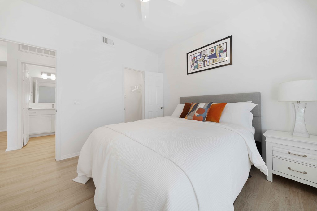 A bedroom with a large bed and a white dresser.