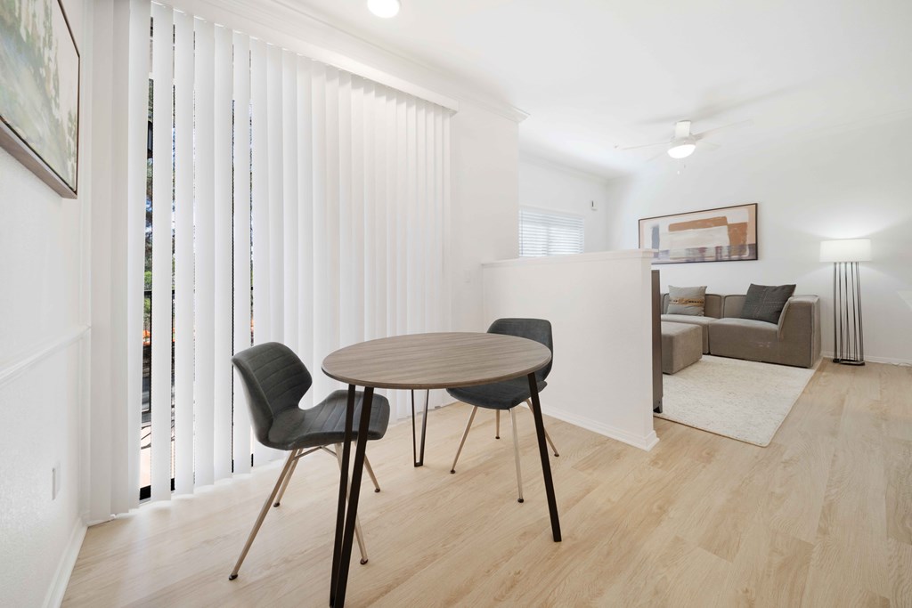 A dining room with a table and chairs.