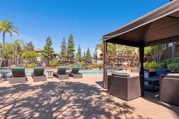 A poolside area with lounge chairs and a canopy.