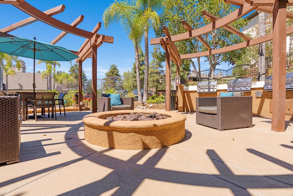 A patio with a fire pit and seating area.