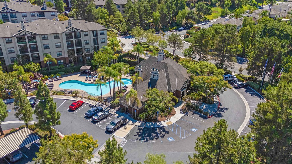 A large apartment complex with a pool and a parking lot.