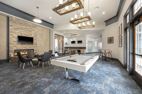 Community clubroom with modern decor, a pool table, and a fireplace