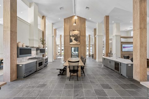 A modern kitchen with a dining table and chairs in the middle.