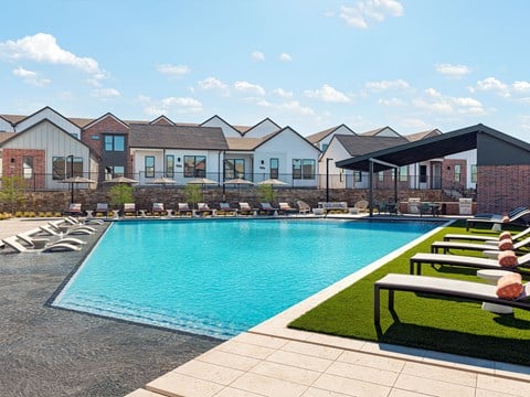 Resort style pool with tanning deck and outdoor grilling stations
