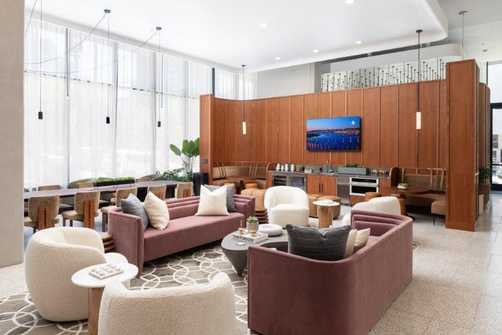 A modern living room with a large screen TV mounted on the wall.