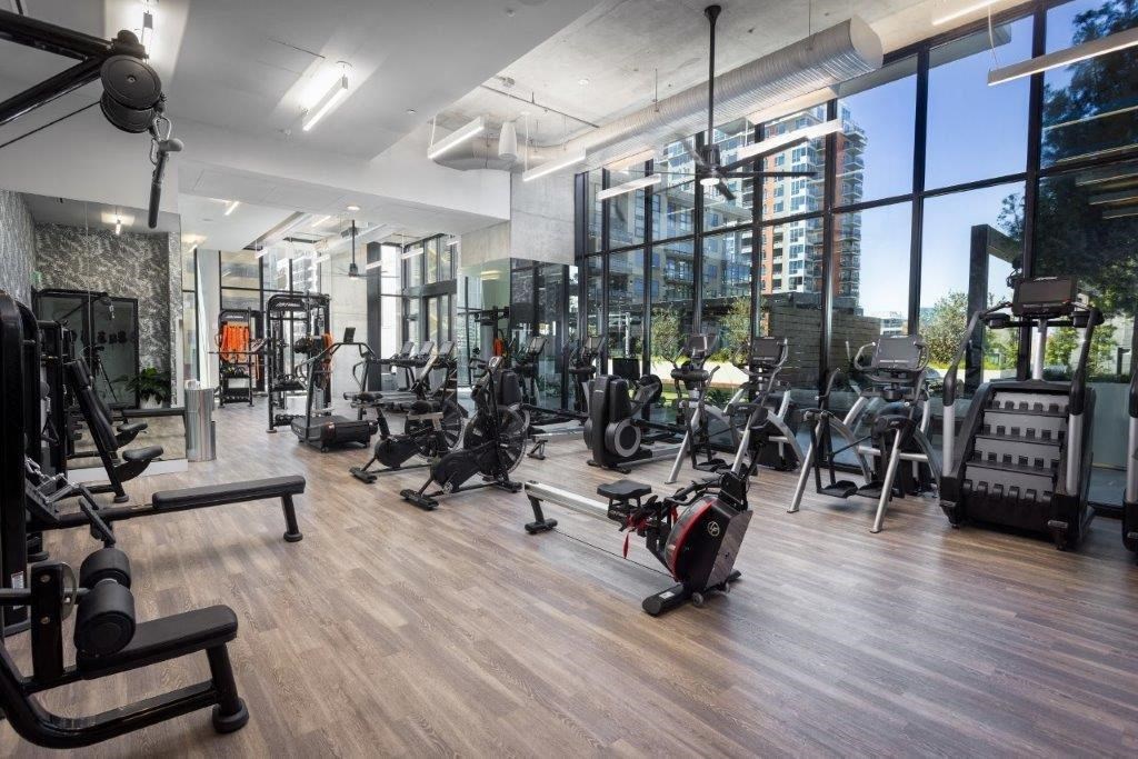 A gym with a variety of equipment including treadmills, weights, and exercise machines.