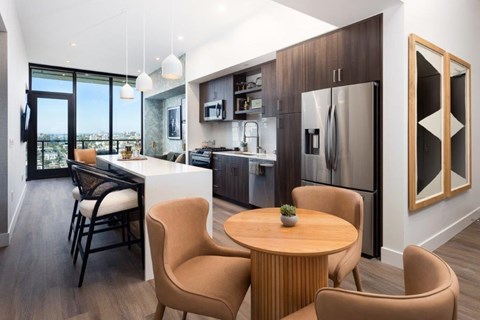 A modern kitchen with a dining table and chairs.