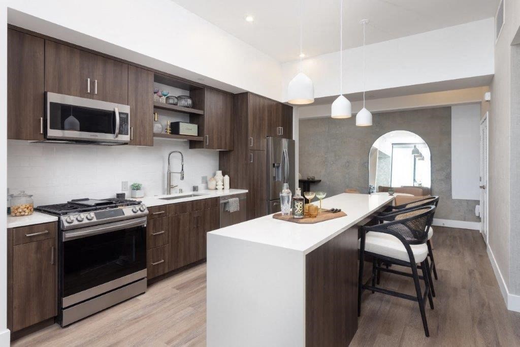 A modern kitchen with dark wood cabinets and a white island.