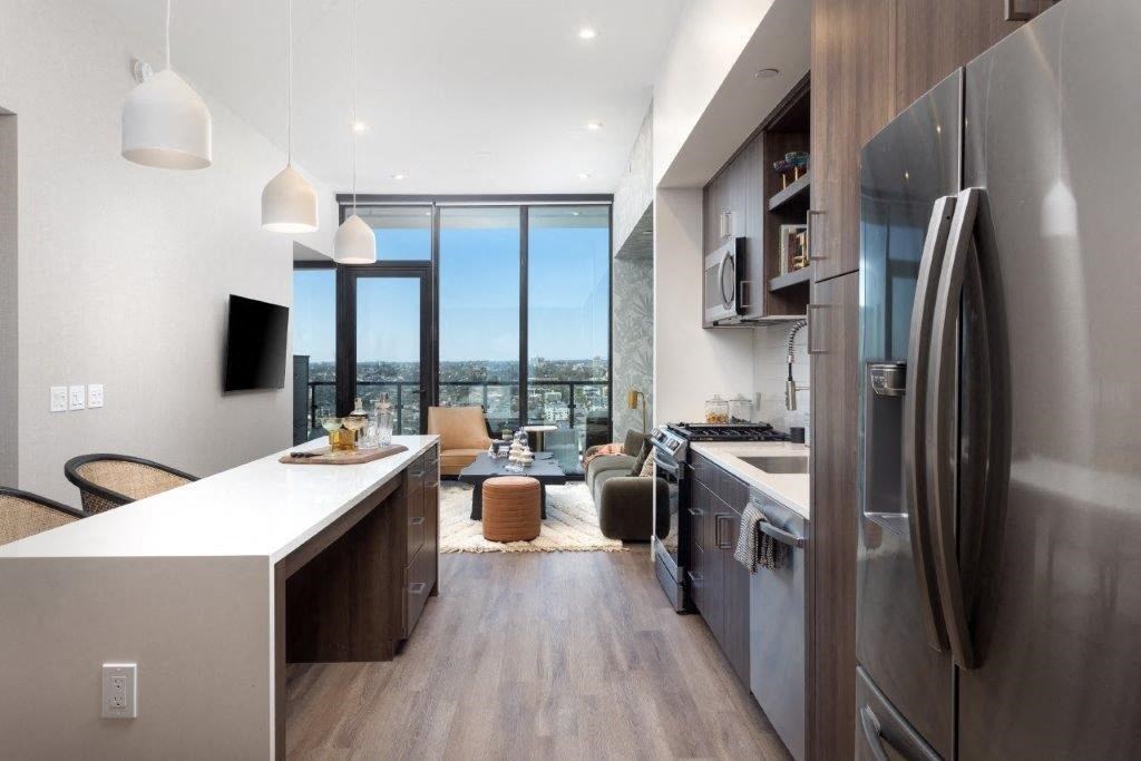 A modern kitchen with a large island and stainless steel appliances.