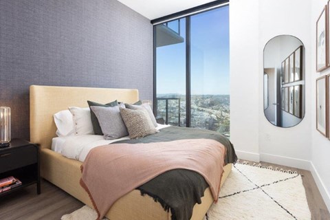 A bedroom with a large bed and a view of the city.