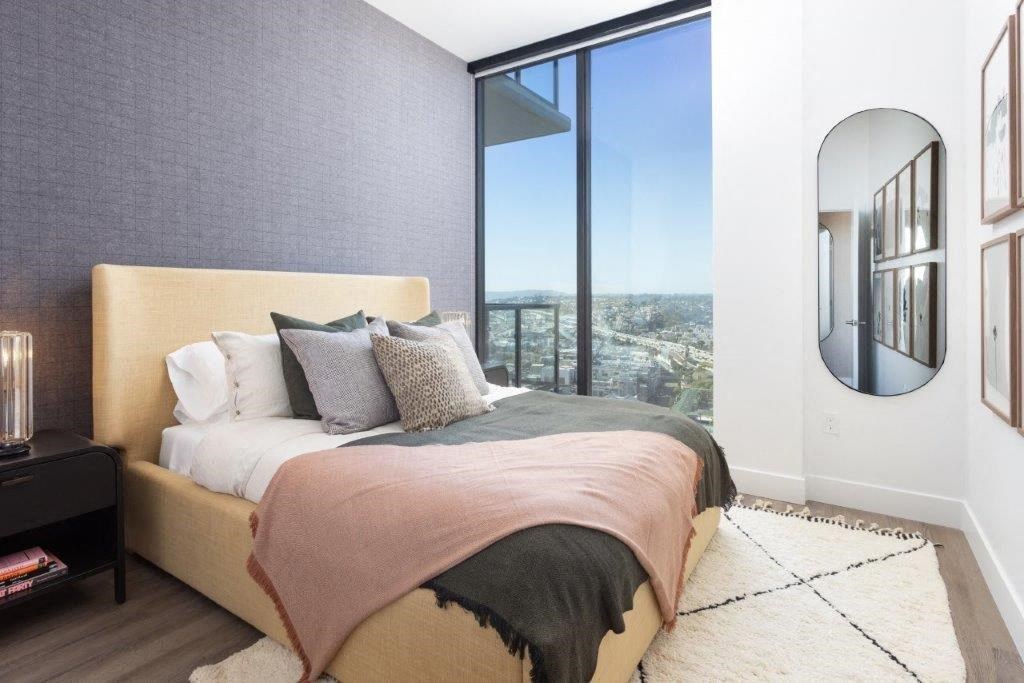 A bedroom with a large bed and a view of the city.