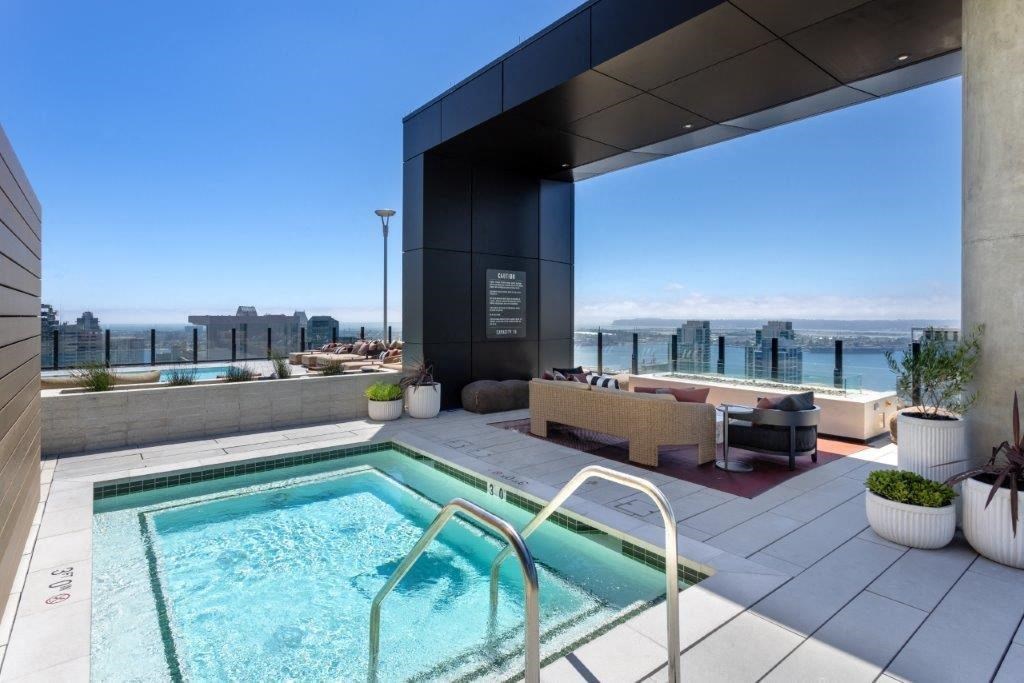 A modern outdoor pool area with a view of the city.