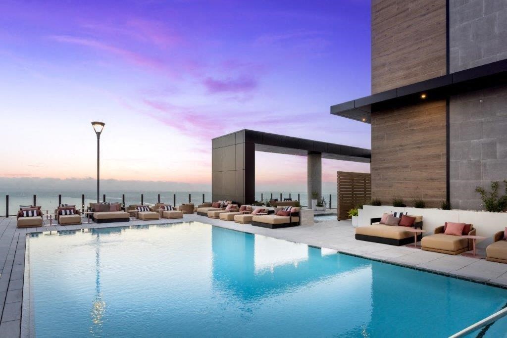 A modern poolside lounge area with a view of the water.