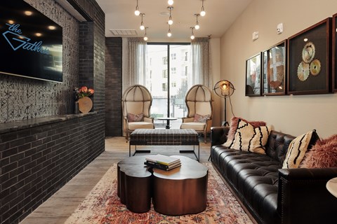 A living room with a black couch and a coffee table.